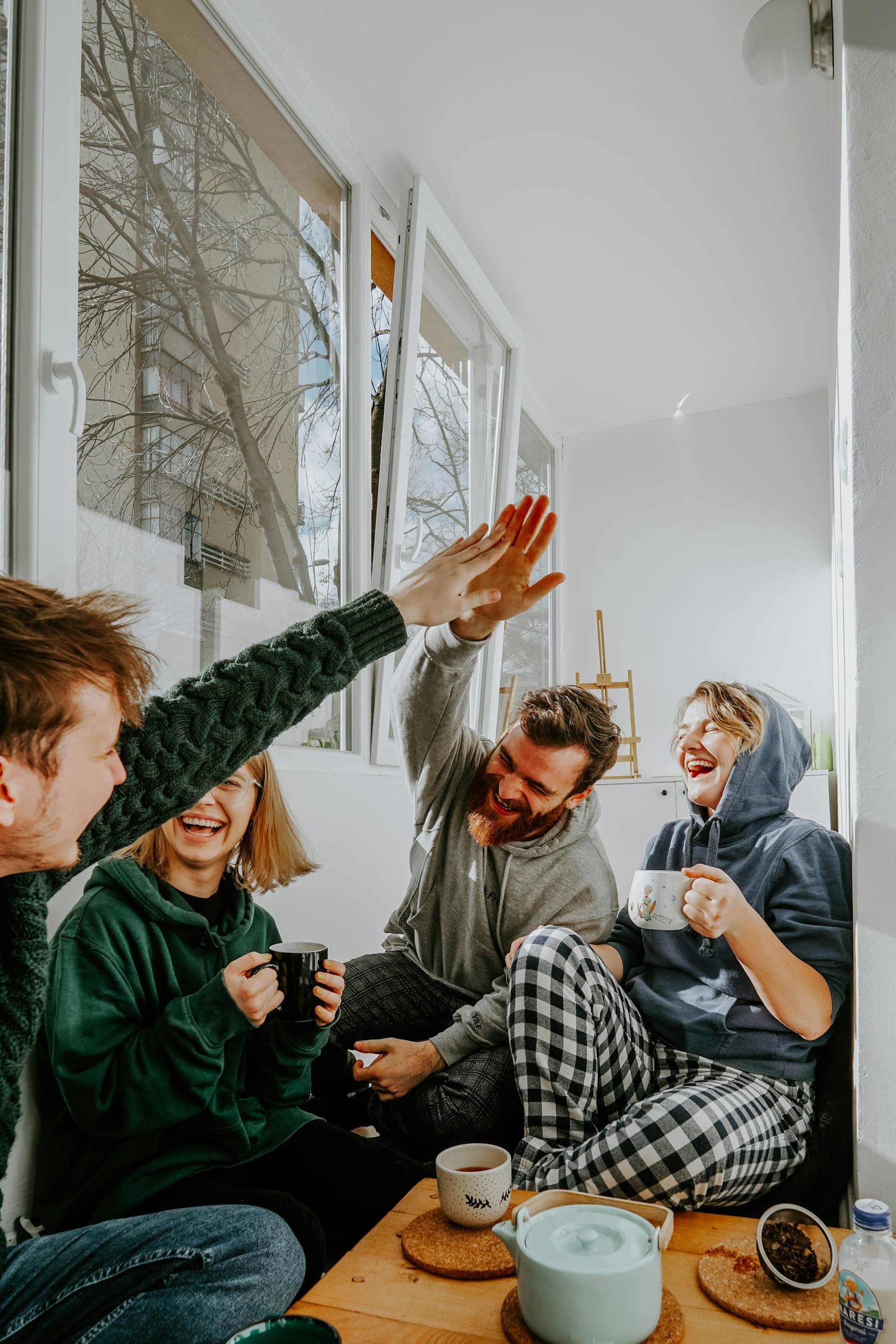 Four friends laughing together over coffee