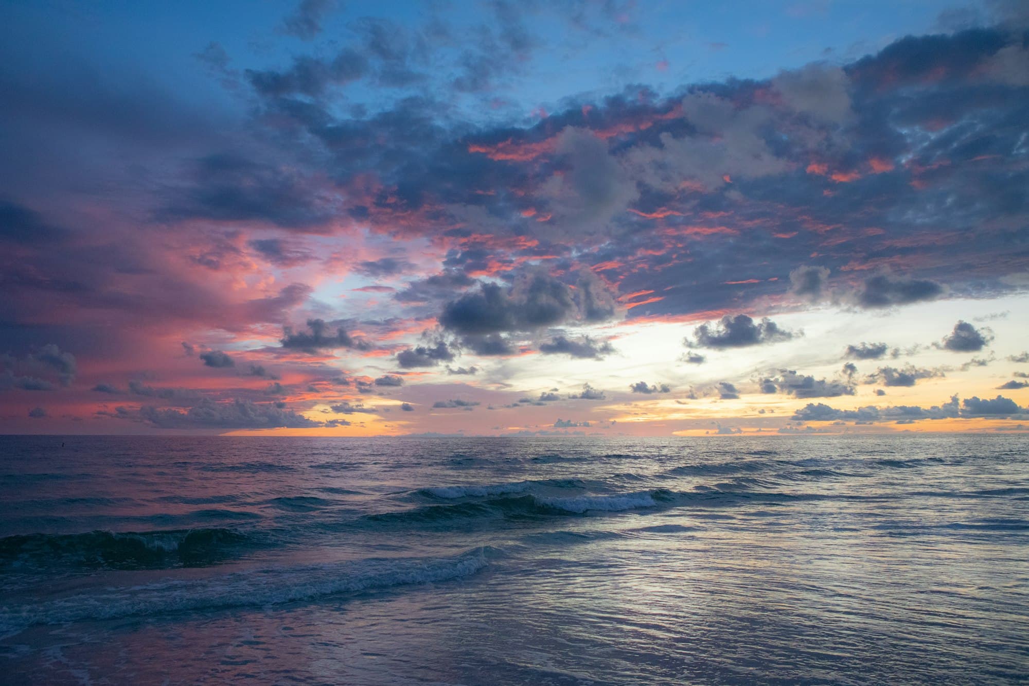 Soft white clouds over a bright seashore