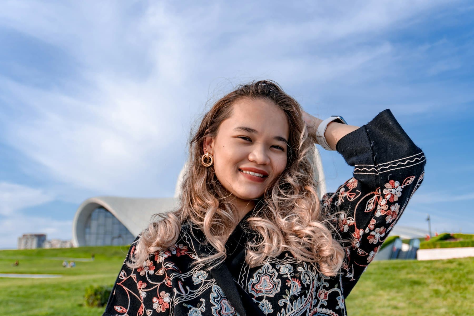 Young woman smiling warmly with her hand in her hair